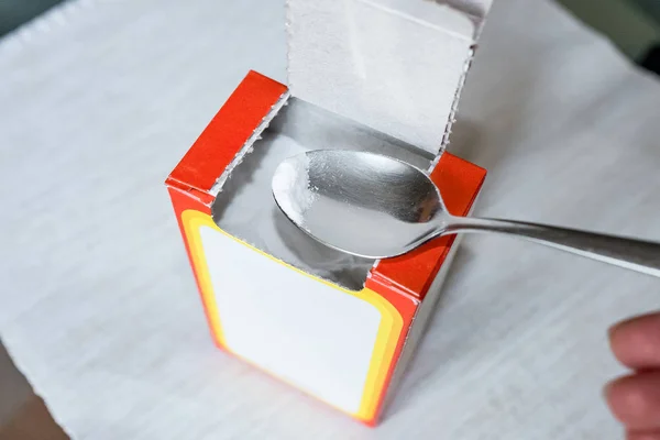 Содовый порошок на ложке. Сода из картонной коробки — стоковое фото