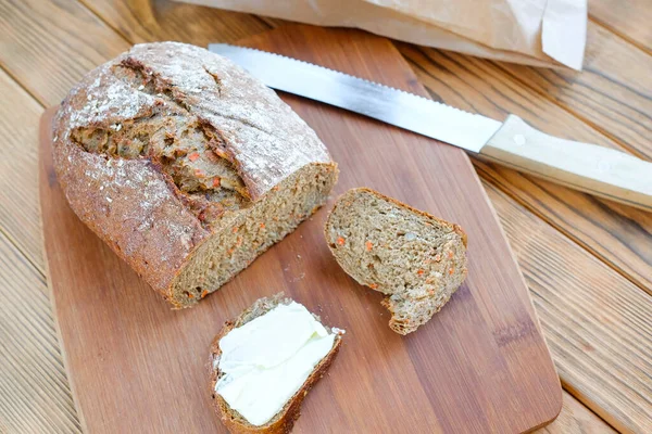 도마 위에서 당근 빵을 썰었습니다. 빵 포장. 위에서 바라본 경관 — 스톡 사진