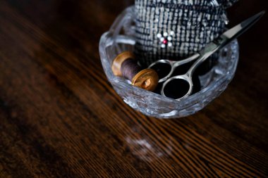 Örgü örmek için aletler. Kristal bir vazoda makas, bir makara iplik ve iğneler. Metin için yer