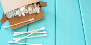 Turkuaz arka planda çevre dostu kozmetik çubuklar.