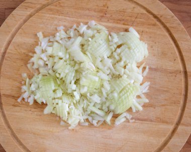 Kesme tahtasında ince doğranmış soğanlar..