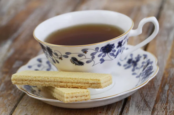 Cup of tea in vintage cup and vanilla wafers