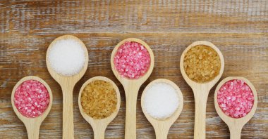 Tahta kaşıklar üzerinde beyaz, pembe ve kahverengi şeker