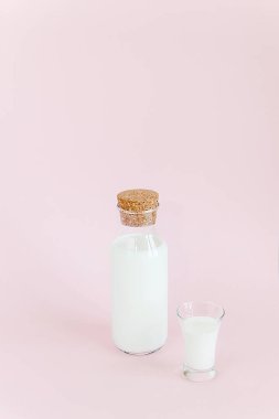 Pembe bir arka plan üzerinde şişe süt