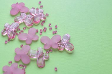 Oval boncuk ve kelebek boncuk gren arka plan üzerinde. Arka plan olarak, kartları kullanın. El sanatları ve hobi aksesuarları