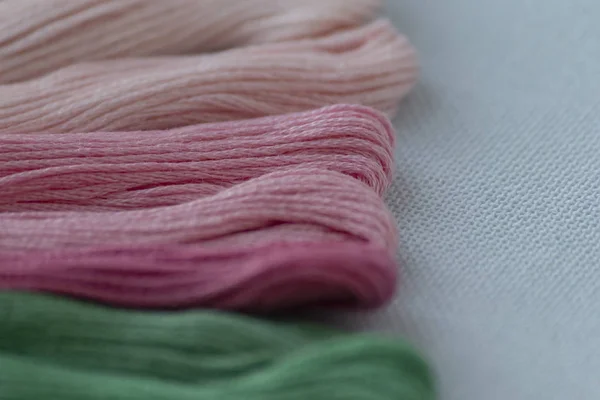 Multi-colored threads for embroidery on light canvas. Place for text