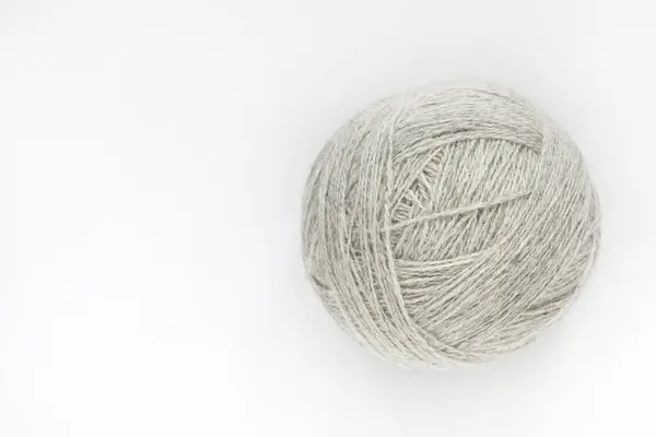 A ball of yarn of natural color on a light background. Close-up. Copy space — Stock Photo, Image