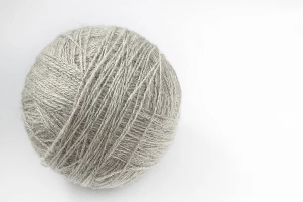 A ball of yarn of natural color on a light background. Close-up. Copy space — Stock Photo, Image