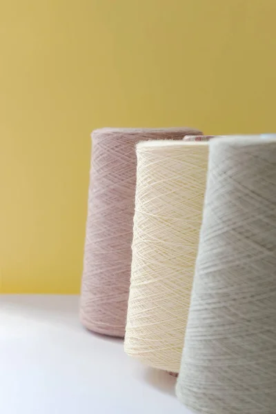 Pastel bolhas de cor de fios de lã para mão e máquina de tricô em um fundo amarelo — Fotografia de Stock