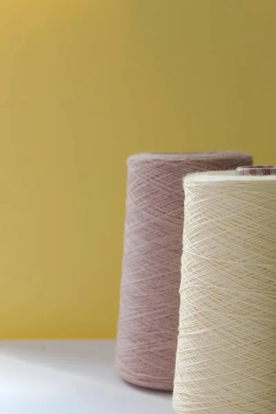 Pastel bolhas de cor de fios de lã para mão e máquina de tricô em um fundo amarelo — Fotografia de Stock