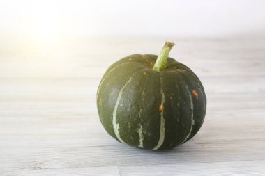 Açık bir arka plan üzerinde yeşil olgun kabak. Sonbahar hasadı. Halloween