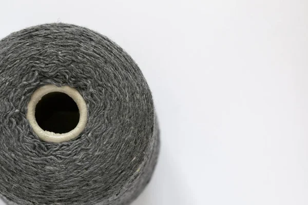 Canette de fils gris pour tricoter à la main et à la machine en gros plan. Vue du dessus arrière-plan, espace pour le texte — Photo