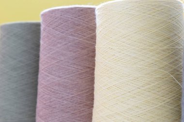 Sarı bir arka plan üzerinde el ve makine örme için yün iplik pastel renk bobinler