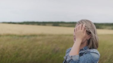 Tarladaki kıza rüzgâr saçlarını uzatır.