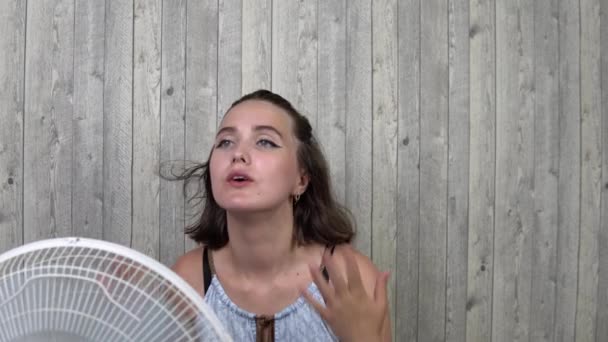 The girl is blown by a fan, in the summer season — Stock Video