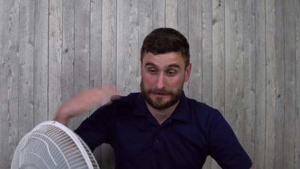 El tipo es soplado por un ventilador, en la temporada de verano — Vídeo de stock