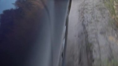 Araba tekerleği yaklaş. Araba toprak bir yolda gidiyor.