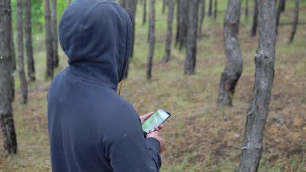 Άνθρωπος Κουκούλα Στο Δάσος Έναν Πλοηγό Ένα Smartphone — Αρχείο Βίντεο