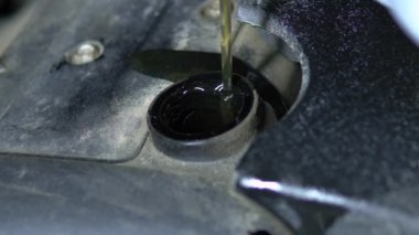 Araba yağı motorun boynuna dökülüyor.