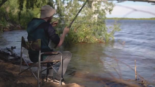 Ψαράς Ρίχνει Ένα Γάντζο Στο Ποτάμι Και Προσεκτικά Monitors4K — Αρχείο Βίντεο