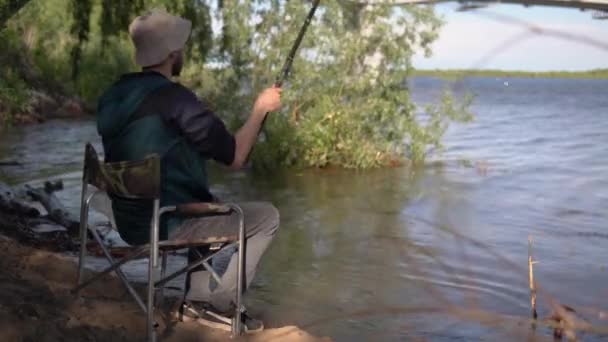 Fischer Zieht Einen Haken Aus Dem Wasser Und Kontrolliert Den — Stockvideo