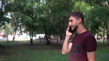Parkta bir adam telefonda konuşuyor.