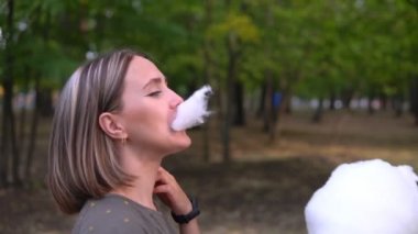 Dışarıda elinde pamuk tutan ve dışarıda yemek yiyen bir kadın.