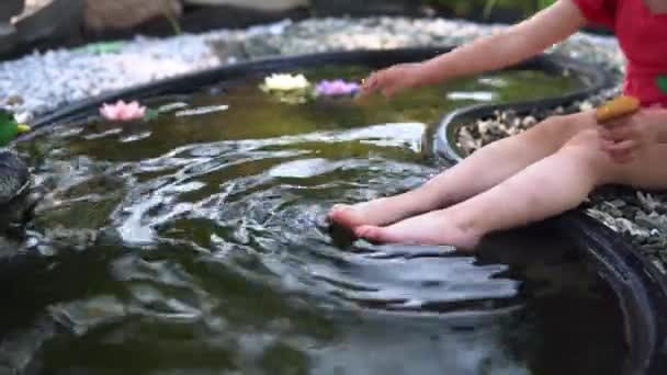 소녀는 버섯을 씻습니다 연못의 다리에 물주는 — 비디오
