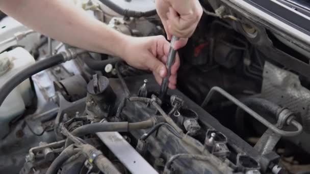 Een Man Trekt Een Oude Bougie Uit Een Auto Motor — Stockvideo