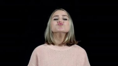 Burnu tıkalı bir kadın siyah arka planda burnuna sprey sıkar.