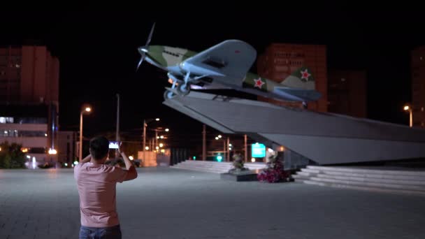 Мужчина фотографирует памятник. Самолет Великой Отечественной войны — стоковое видео