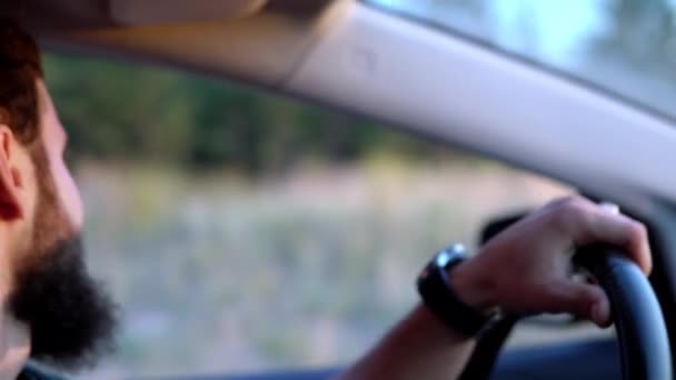 Mladý muž s vousy řídí auto. — Stock video