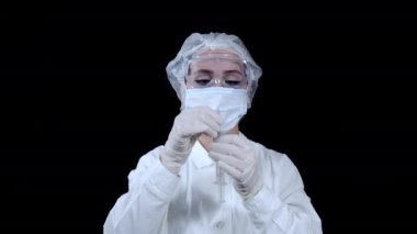 Doktor elinde bir şırınga tutuyor ve içinden hava çıkarıyor.