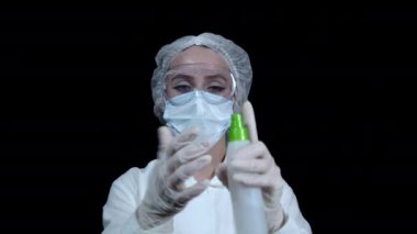 Doktor eline sıktığı spreyden dezenfektan sıkar.