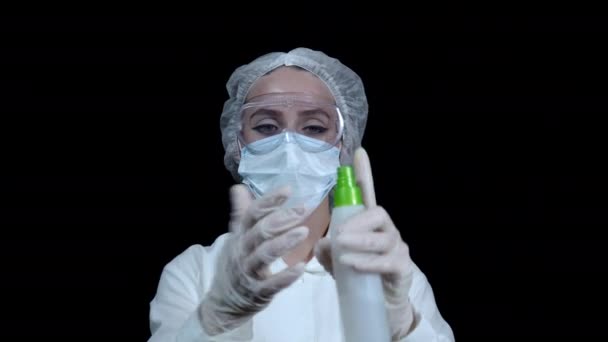 Arzt sprüht Desinfektionsmittel aus dem Spray auf seine Hände in einem medizinischen Handschuh — Stockvideo