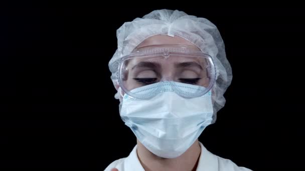 Close-up of a tired nurse after a hard days work takes off her protective gear and loosens her hair — Stock Video