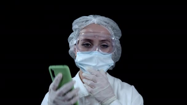 Doctor praten aan de telefoon op een zwarte achtergrond — Stockvideo