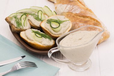 Forshmak ekmek ile bulaşmış. Dereotu ve salatalık gibi yemekleri macun ile bir dizi ile dekore edilmiş.