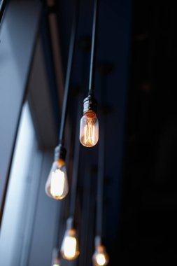 Retro ampuller ile zayıf kızdırma teller üzerinde tavana asılı.