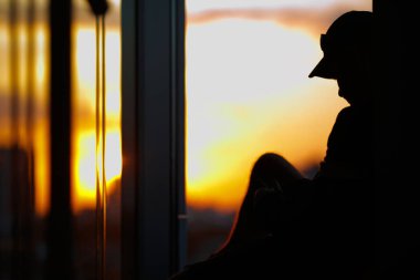 Adam günbatımı arka plan üzerinde. O yüksek katta yer alan ve bir güzel dışında göster.