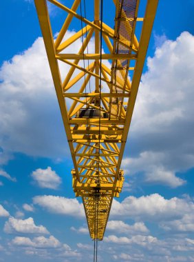 Sarı vinç açık mavi gökyüzü yemyeşil bulutlar ile karşı.
