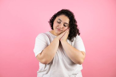 Genç, güzel bir kadın, günlük beyaz tişört giyer, pembe arka planda dikilir, uyur, yorgun düşler görür, ellerle poz verir, kapalı gözlerle gülümserdi..