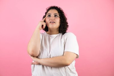 Soyutlanmış pembe arka planda duran genç ve güzel bir kadın. Hatayla el ele tutuşup şaşırdı. Hatayı hatırla.