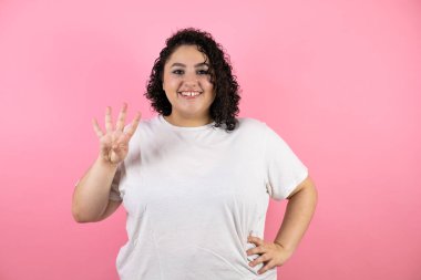 Güzel genç bir kadın kendini beğenmiş ve mutlu bir şekilde gülümserken dört numarayı gösterip işaret ediyor.