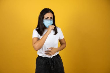 Koronavirüsün belirtisi olarak kendini kötü hisseden ve öksüren genç ve güzel bir kadın. Giyinme izi. Sağlık kavramı.