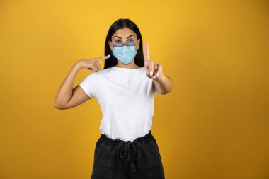 Koronavirüsten korunmak için maske takan genç ve güzel bir kadın salgını durdurmak için bunu tavsiye ediyor. Covid 19