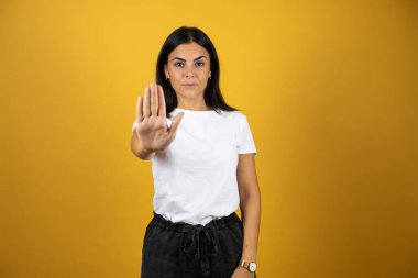 Soyutlanmış sarı arka planda genç bir kadın avucunun içi gibi şarkı söylemeyi kesiyor. Yüzünde olumsuz ve ciddi bir jest olan uyarı ifadesi.