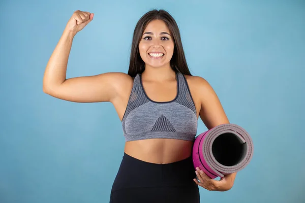 Mooie Vrouw Draagt Sportkleding Geïsoleerde Blauwe Achtergrond Met Armen Spieren — Stockfoto