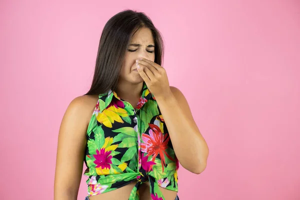 Jovem Mulher Bonita Sobre Fundo Rosa Isolado Cheirando Algo Fedorento — Fotografia de Stock