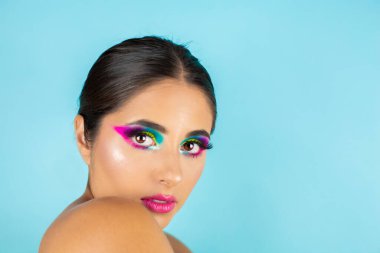 Mavi arka planda canlı makyajlı kadın modelin güzel portresi.